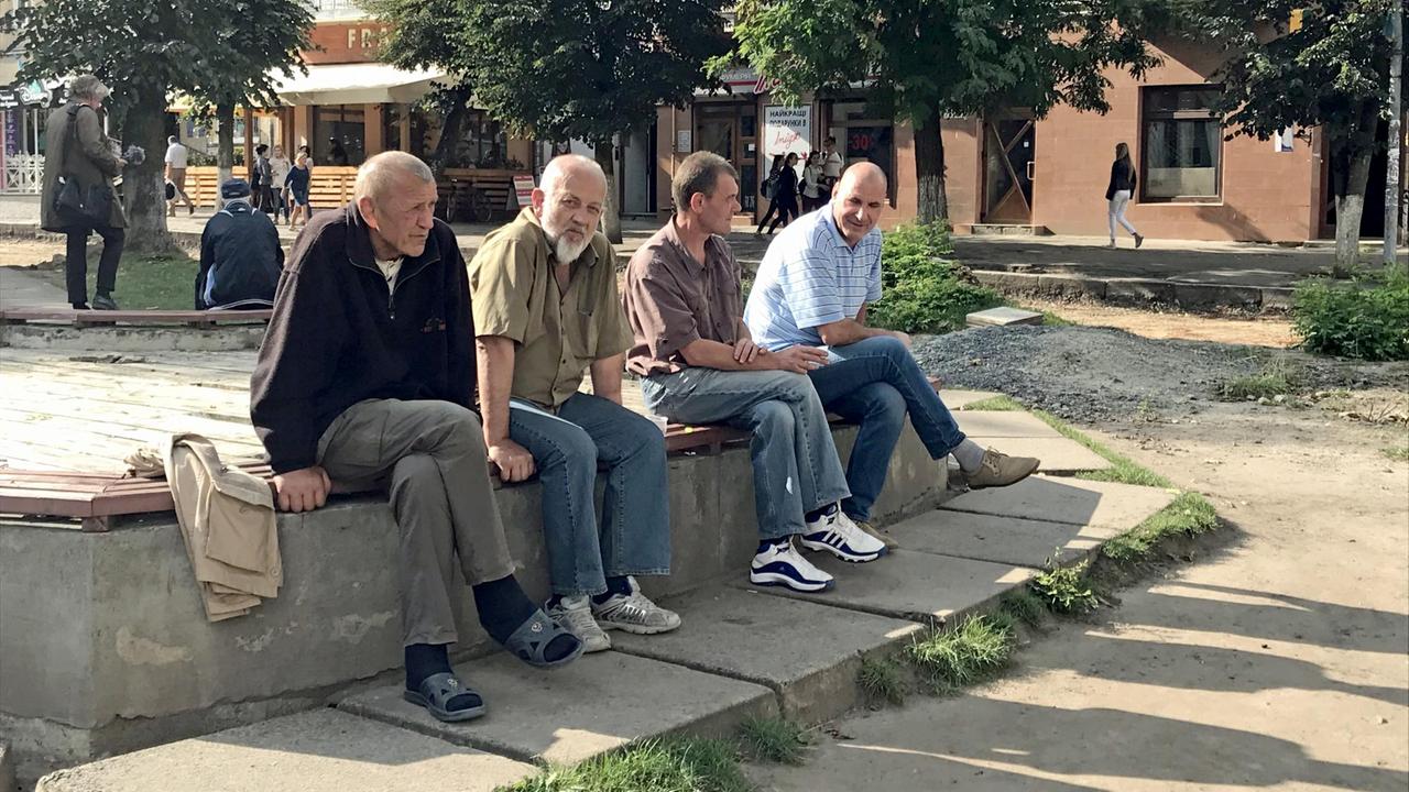 Alte Männer sitzen in der urkainischen Stadt Drohobytsch auf einer kleinen Mauer. Alte Männer sitzen in der urkainischen Stadt Drohobytsch auf einer kleinen Mauer.