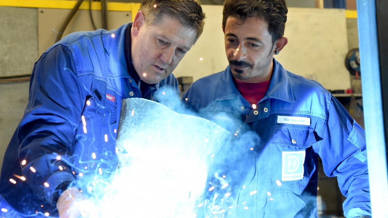 Ein syrischer Flüchtling arbeitet mit seinem Ausbilder in einem Metallbetrieb in Schleswig-Holstein Ein syrischer Flüchtling arbeitet mit seinem Ausbilder in einem Metallbetrieb in Schleswig-Holstein