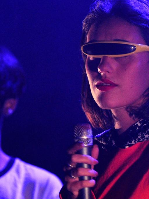 Sängerin und Mitglied der französischen Rockband Agar Agar Clara Cappagli steht im Juli 2017 mit einer futuristischen Sonnenbrille auf einer Bühne.