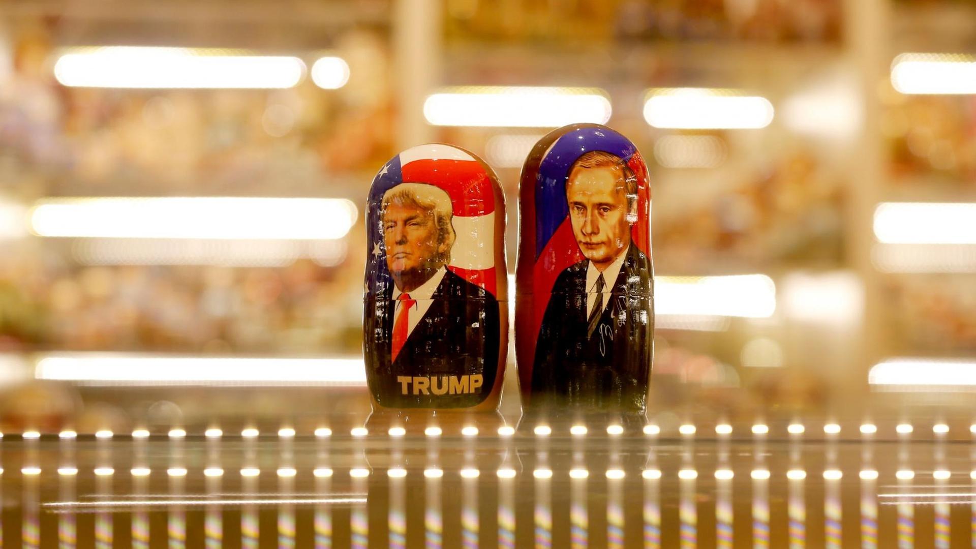 Zwei bemalte Matroschka-Puppen von Wladimir Putin und Donald Trump auf der gläsernen Theke eines Souvenirgeschäft. Zwei bemalte Matroschka-Puppen von Wladimir Putin und Donald Trump auf der gläsernen Theke eines Souvenirgeschäft.