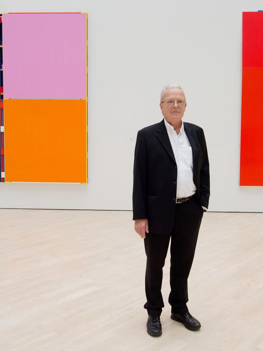 Der Künstler Imi Knoebel 2014 vor seinen Werken "Aliaaa" (l, 2002) und "Ich Nicht X" (2006) in der Ausstellung "Imi Knoebel. Werke 1966-2014" im Kunstmuseum in Wolfsburg.