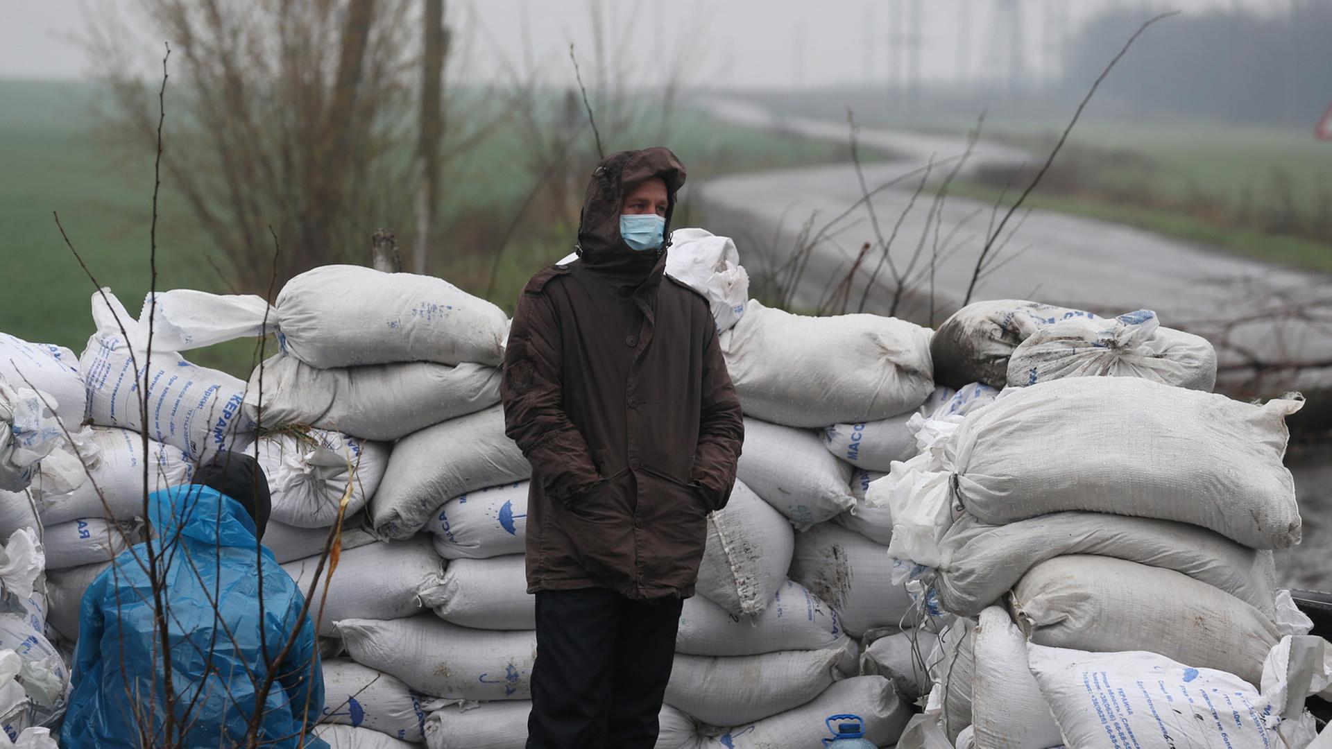 Ukrainische Männer hinter einer Barrikade, die sie an einer Zufahrtsstraße nach Slawiansk errichtet haben, 13. April 2014. Ukrainische Männer hinter einer Barrikade, die sie an einer Zufahrtsstraße nach Slawiansk errichtet haben, 13. April 2014.