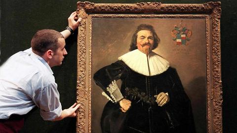 Das Gemälde von Franz Hals mit dem Porträt des Tuchhändlers Tieleman Roosterman rückt ein Angestellter des Londoner Auktionshauses Christie's am 12.4. zurecht.
