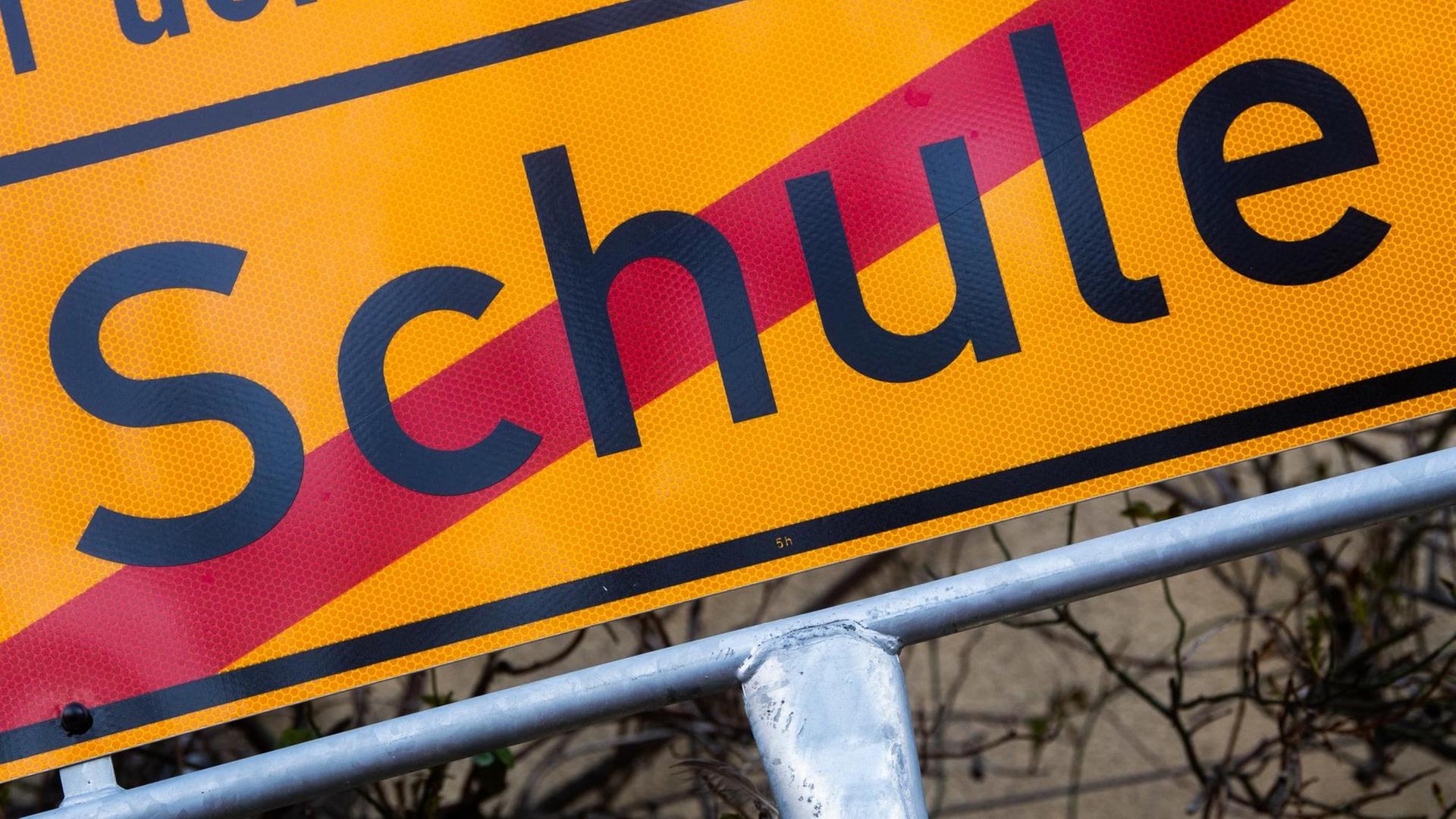 Ein Schild mit einem durchgestrichenen Schriftzug "Schule" Ein Schild mit einem durchgestrichenen Schriftzug "Schule"