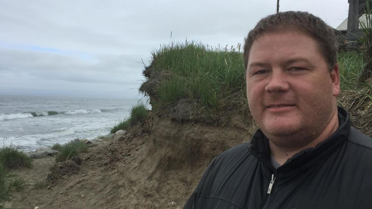 Lehrer Ken Senek steht an der wegerodierten Abbruchkante im Norden der Insel. Hier ist vor einigen Jahren ein Haus ins Meer gestürzt Lehrer Ken Senek steht an der wegerodierten Abbruchkante im Norden der Insel. Hier ist vor einigen Jahren ein Haus ins Meer gestürzt