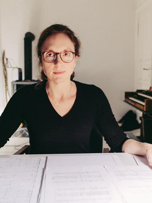 Rebecca Saunders sitzt in einem Arbeitszimmer an einem Schreibtisch