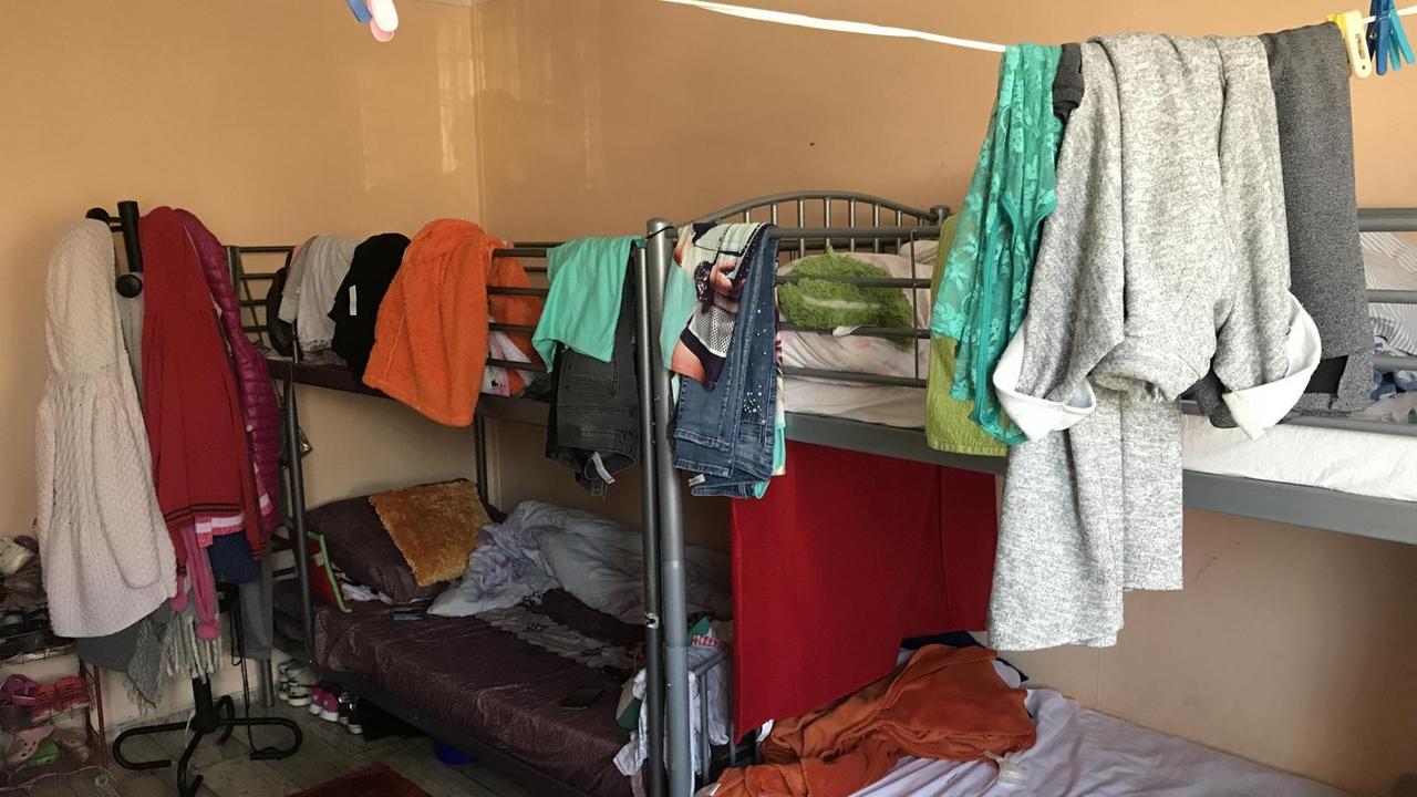 Zimmer kit Doppelstockbetten, zwischen denen Wäsche auf Schnüren trocknet. Zimmer kit Doppelstockbetten, zwischen denen Wäsche auf Schnüren trocknet.