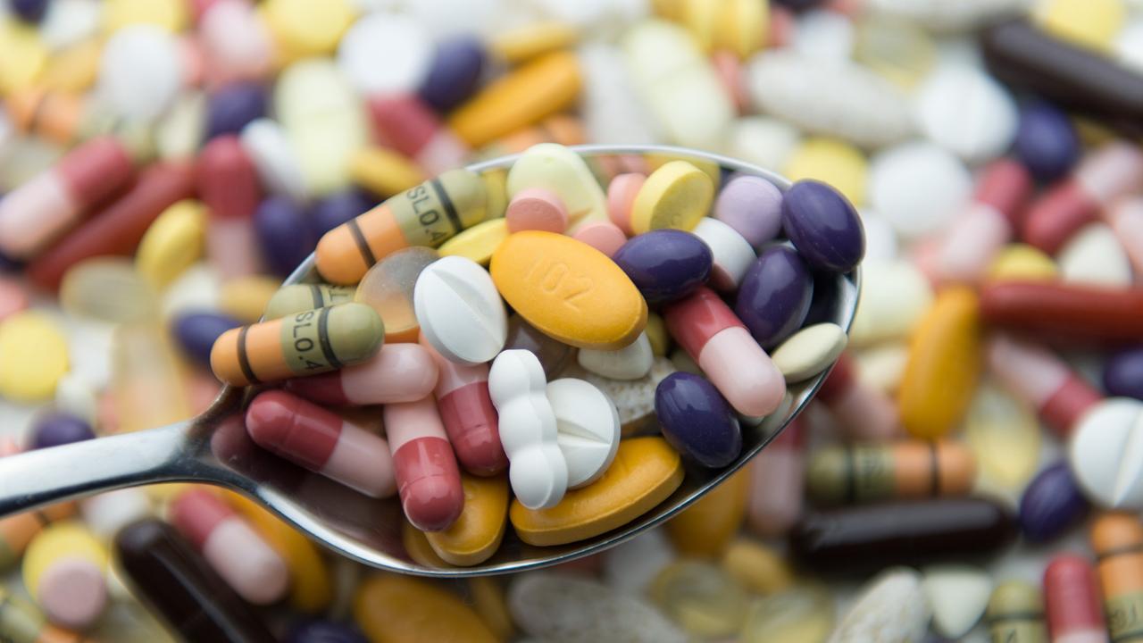 Zahlreiche Pillen und Tabletten liegen auf einem Tisch und auf einem Löffel. Zahlreiche Pillen und Tabletten liegen auf einem Tisch und auf einem Löffel.