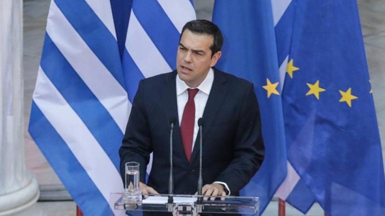 Der griechische Premierminister Alexis Tsipras bei einer Rede in Athen, bei der er eine rote Krawatte trägt
