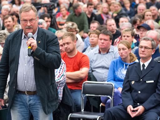 Der Ortsvorsteher Christian Fabel (CDU, stehend) stellt am 28. Oktober 2015 während einer Bürgerversammlung in Neuhaus zur geplanten Flüchtlingsunterbringung in der Ortschaft Sumte Fragen.