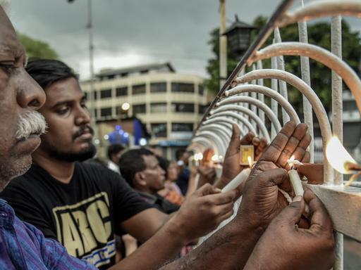 Trauernde Menschen aus Sri Lanka zünden am 23. April 2019 in der Nähe der Kirche St. Anthony in Colombo Kerzen für die Terroropfer vom Ostersonntag an.