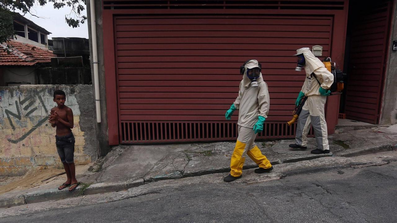 Helfer mit Gasmasken laufen durch die Straßen von Sao Paulo. Helfer mit Gasmasken laufen durch die Straßen von Sao Paulo.