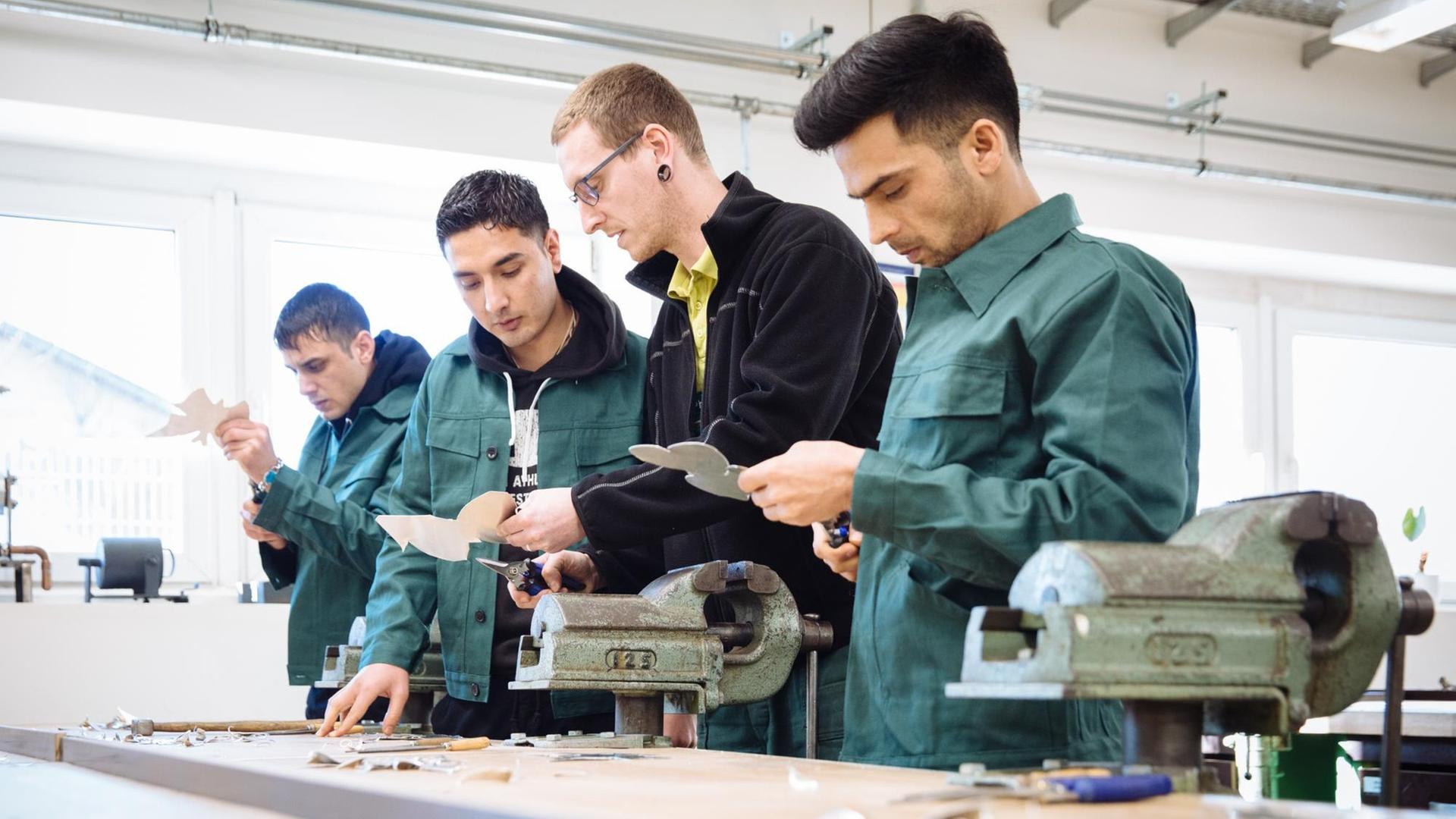 Sachsen, Heidenau: Junge Geflüchtete aus Afghanistan werden im Unterricht der AMS Ausbildungsgesellschaft für Metalltechnik und Schweißer von Ausbilder Philipp Rokasky (2.v.r.) angeleitet. Sachsen, Heidenau: Junge Geflüchtete aus Afghanistan werden im Unterricht der AMS Ausbildungsgesellschaft für Metalltechnik und Schweißer von Ausbilder Philipp Rokasky (2.v.r.) angeleitet.