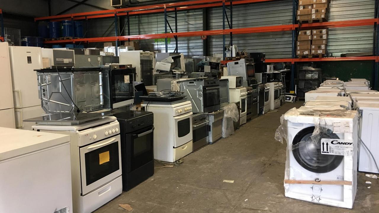 Alte Haushältsgeräte wie Elektroherde und Waschmaschinen in einem Lagerraum Alte Haushältsgeräte wie Elektroherde und Waschmaschinen in einem Lagerraum