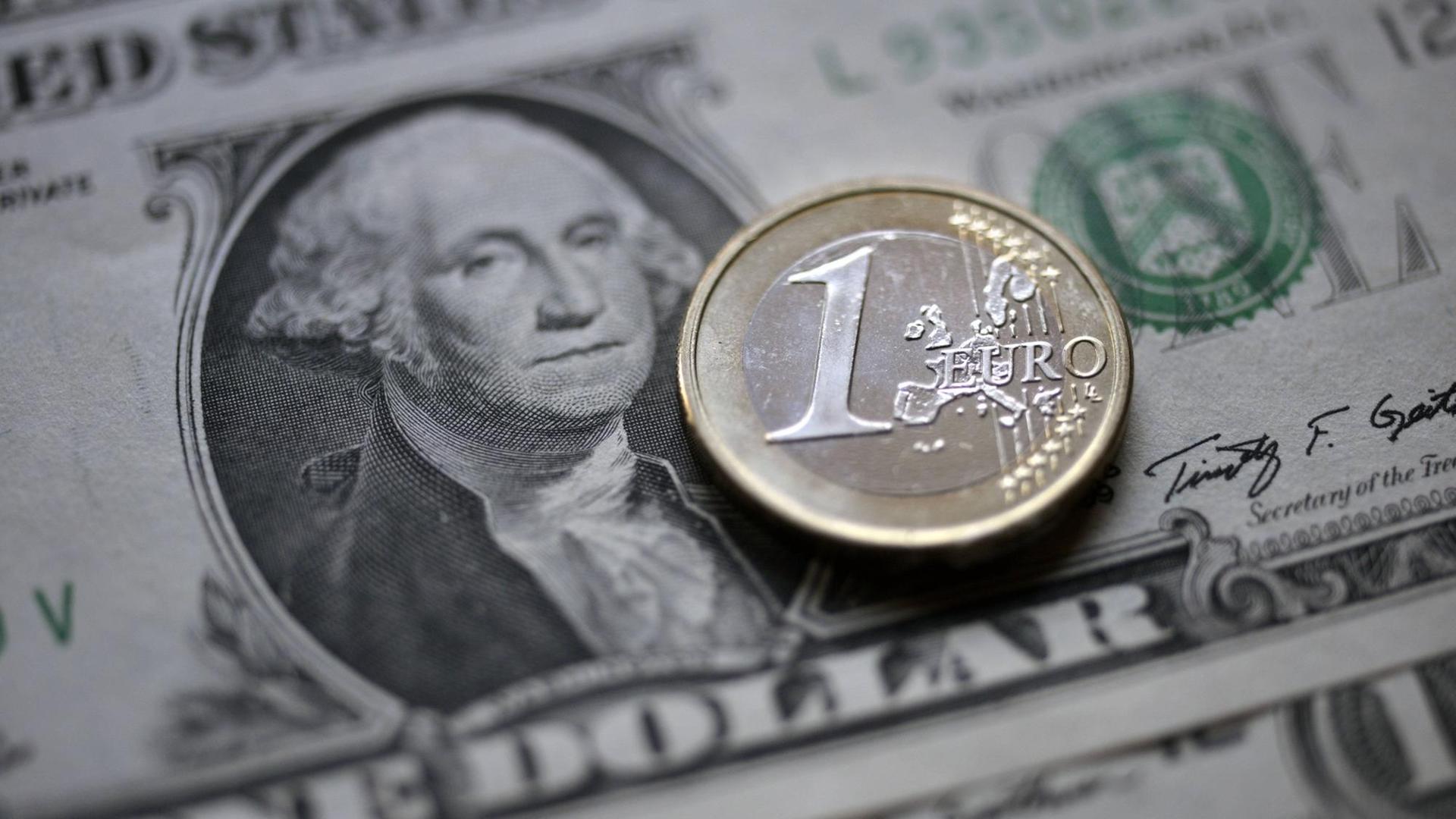 Eine Euromünze auf einem Dollar Schein Eine Euromünze auf einem Dollar Schein