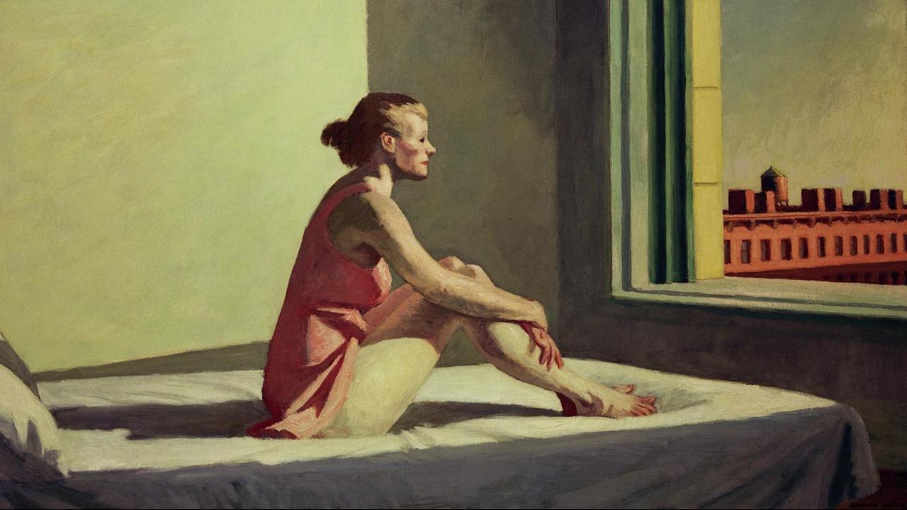 Eine junge Frau sitzt auf einem Bett und blickt melancholisch aus dem Fenster. Eine junge Frau sitzt auf einem Bett und blickt melancholisch aus dem Fenster.