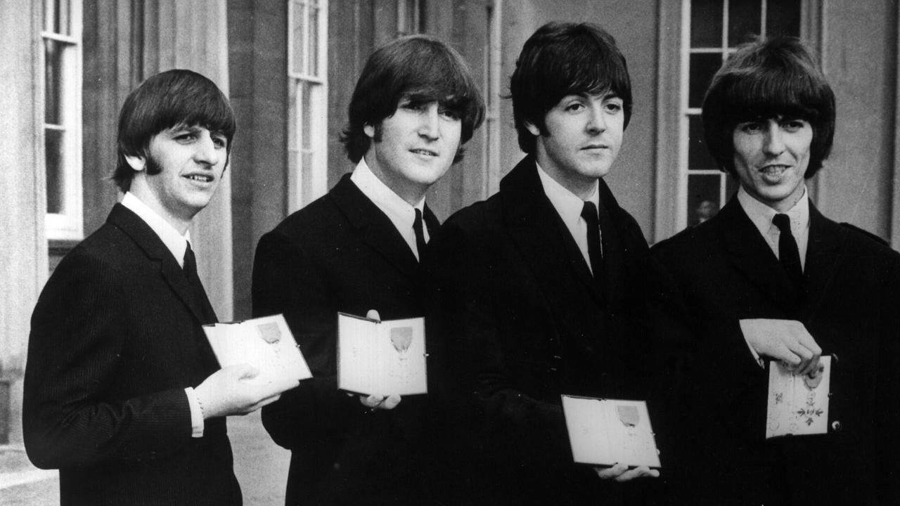 Die Beatles (von links nach rechts): Ringo Starr, John Lennon, Paul McCartney und George Harrison, präsentieren 1965 in London ihre von der englischen Königin an sie verliehenen Orden "Member of the British Empire".