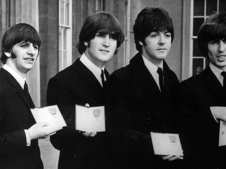 Die Beatles (von links nach rechts): Ringo Starr, John Lennon, Paul McCartney und George Harrison, präsentieren 1965 in London ihre von der englischen Königin an sie verliehenen Orden "Member of the British Empire".