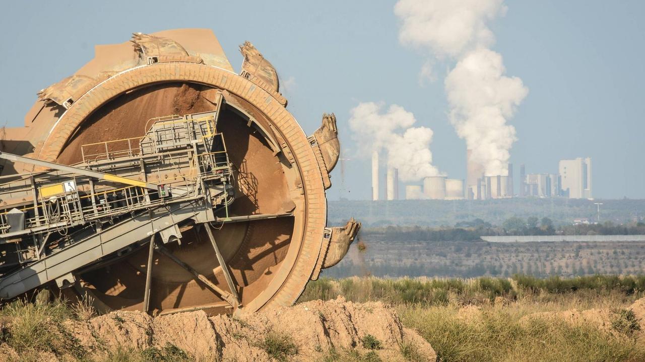 Ein Schaufelradbagger von RWE hinter dem Hambacher Forst vor dem Tagebau Etzweiler. Im Hintergrund das RWE Kraftwerk Niederaußem. Ein Schaufelradbagger von RWE hinter dem Hambacher Forst vor dem Tagebau Etzweiler. Im Hintergrund das RWE Kraftwerk Niederaußem.