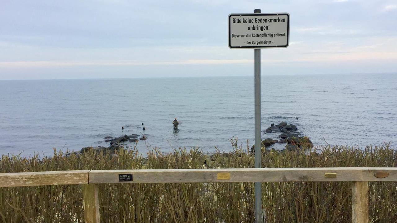 Strandpromenade in Strande mit Gedenkplaketten am Geländer und einem diesbezüglichen Verbotsschild Strandpromenade in Strande mit Gedenkplaketten am Geländer und einem diesbezüglichen Verbotsschild