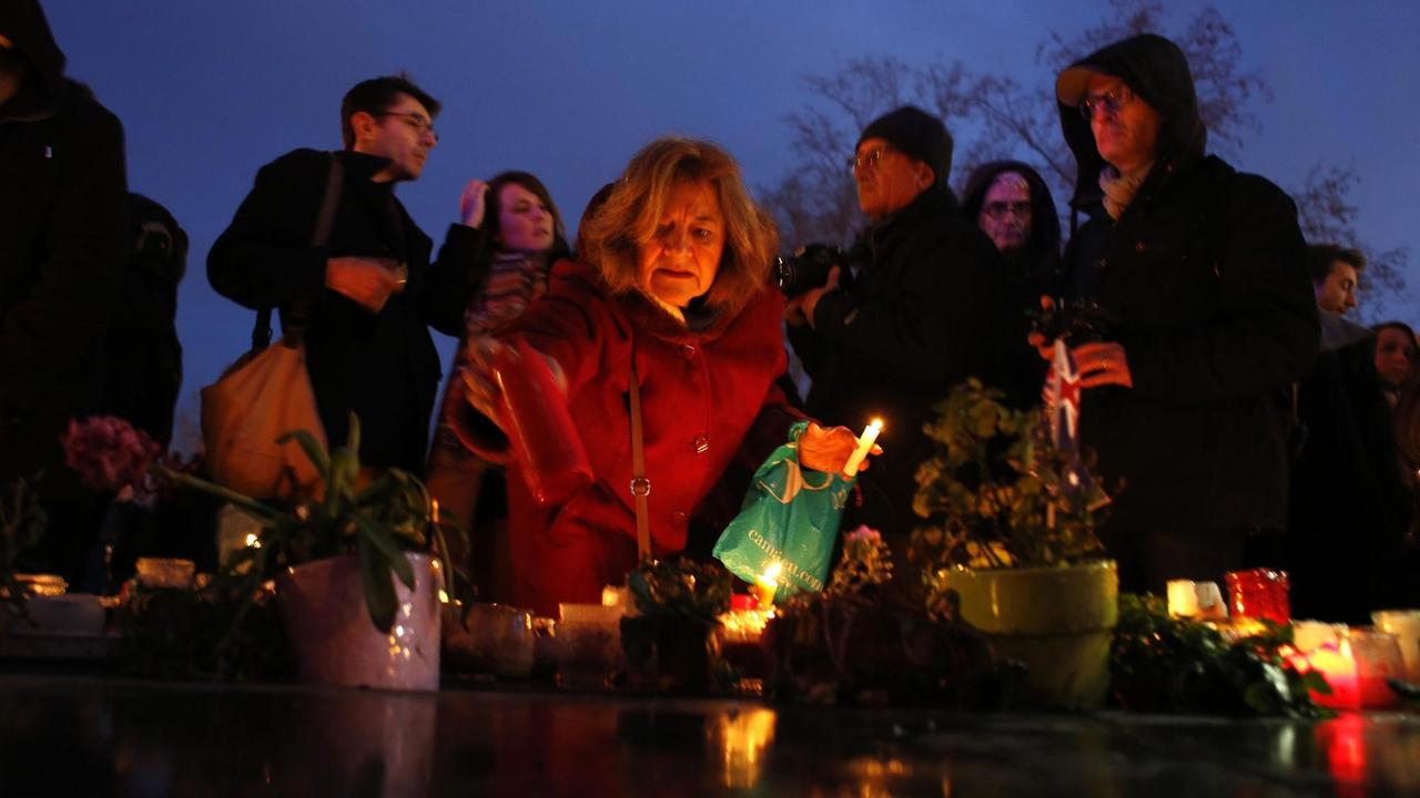 Man sieht Menschen, es ist Abend auf dem Platz der Republik, und es brennen Kerzen. Man sieht Menschen, es ist Abend auf dem Platz der Republik, und es brennen Kerzen.