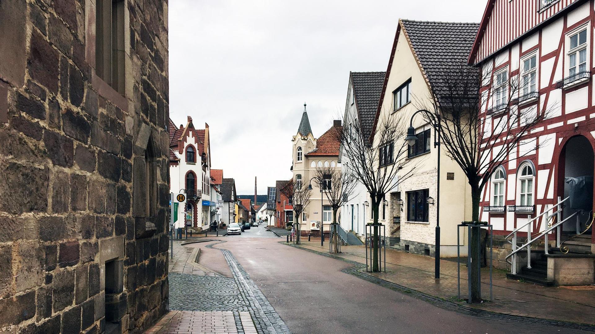 Eine Asphaltstraße führt durch ein Dorf. Das Dorf ist alt: Rechts steht ein Fachwerkhaus. Weitere historische Bauten aus dem späten Mittelater sind zu sehen. Eine Asphaltstraße führt durch ein Dorf. Das Dorf ist alt: Rechts steht ein Fachwerkhaus. Weitere historische Bauten aus dem späten Mittelater sind zu sehen.