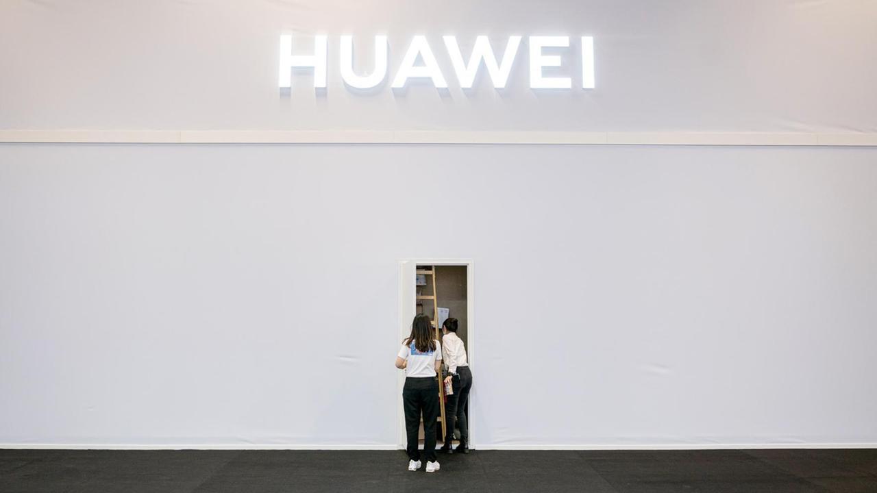 Zwei Mitarbeiter des Technologieunternehmen Huawei in der Internationalen Funkausstellung (IFA) stehen vor einem Seiteneingang des Standes. Zwei Mitarbeiter des Technologieunternehmen Huawei in der Internationalen Funkausstellung (IFA) stehen vor einem Seiteneingang des Standes.