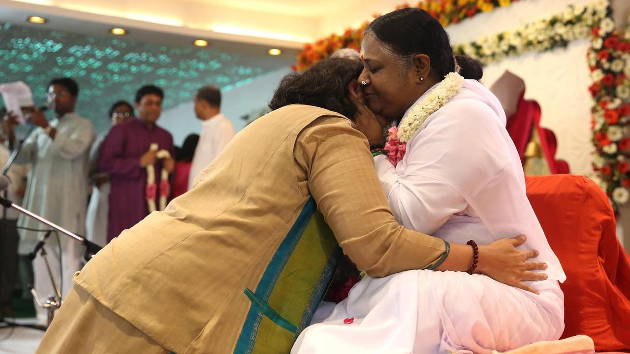 Guru Sri Mata Amritanandamayi Devi - auch Amma genannt - umarmt eine Anhängerin während einer Veranstaltung am 04. April 2016 in Neu-Dehli, Indien. Guru Sri Mata Amritanandamayi Devi - auch Amma genannt - umarmt eine Anhängerin während einer Veranstaltung am 04. April 2016 in Neu-Dehli, Indien.