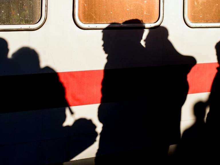 Flüchtlinge laufen am 03.10.2015 nach ihrer Ankunft über den Bahnsteig am Bahnhof in Schönefeld (Brandenburg).