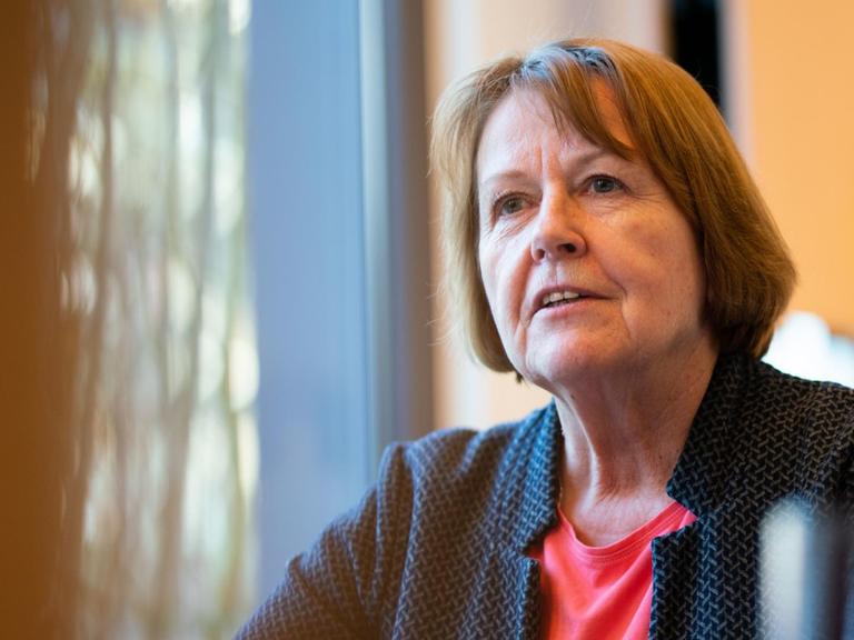 Hannelore Ratzeburg, sie sitzt an einem Tisch neben einem Fenster.