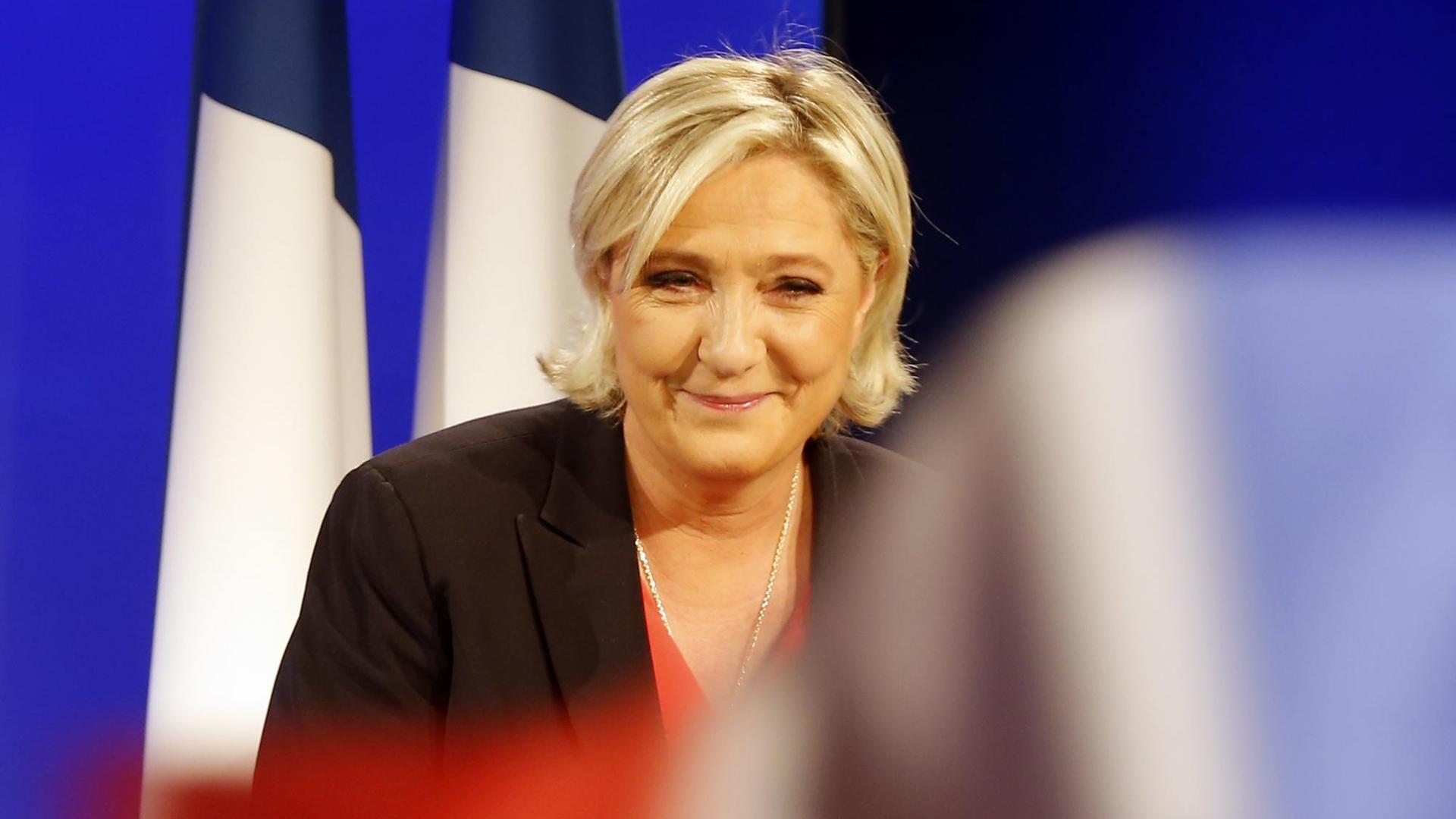 Parteichefin Marine Le Pen hält im Wahl-Hauptquartier des Front National eine Rede - französische Flaggen im Hintergrund. Parteichefin Marine Le Pen hält im Wahl-Hauptquartier des Front National eine Rede - französische Flaggen im Hintergrund.