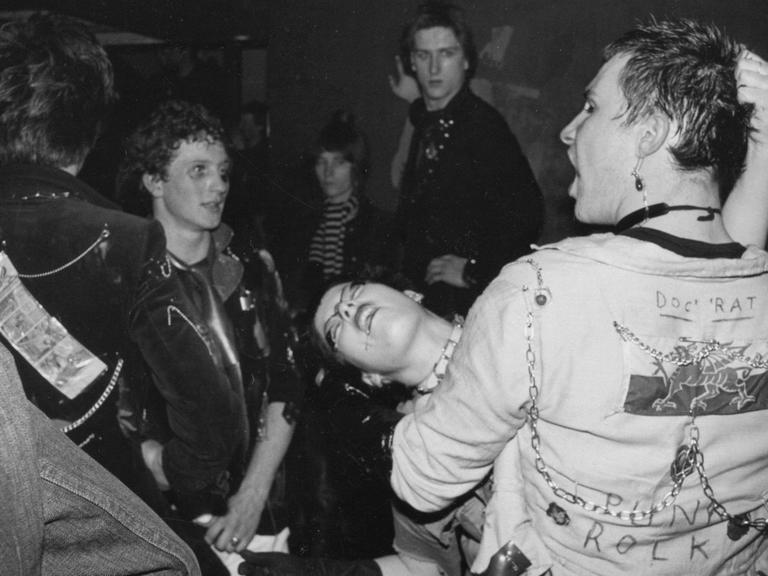 Schwarzweißfoto von Punks in ausgelassenen Posen
