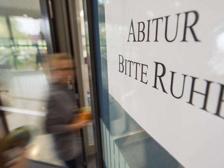 Zwei Schülerinnen gehen am 25.04.2017 im Solitude-Gymnasium in Stuttgart auf dem Weg zum Prüfungsraum an einem Schild mit der Aufschrift "Abitur - Bitte Ruhe" vorbei. (Symbolbild)