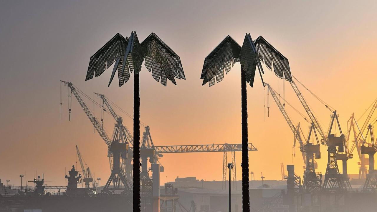 Zwei künstliche Palmen stehen im rötlichen Abendlicht am Hamburger Hafen. Zwei künstliche Palmen stehen im rötlichen Abendlicht am Hamburger Hafen.
