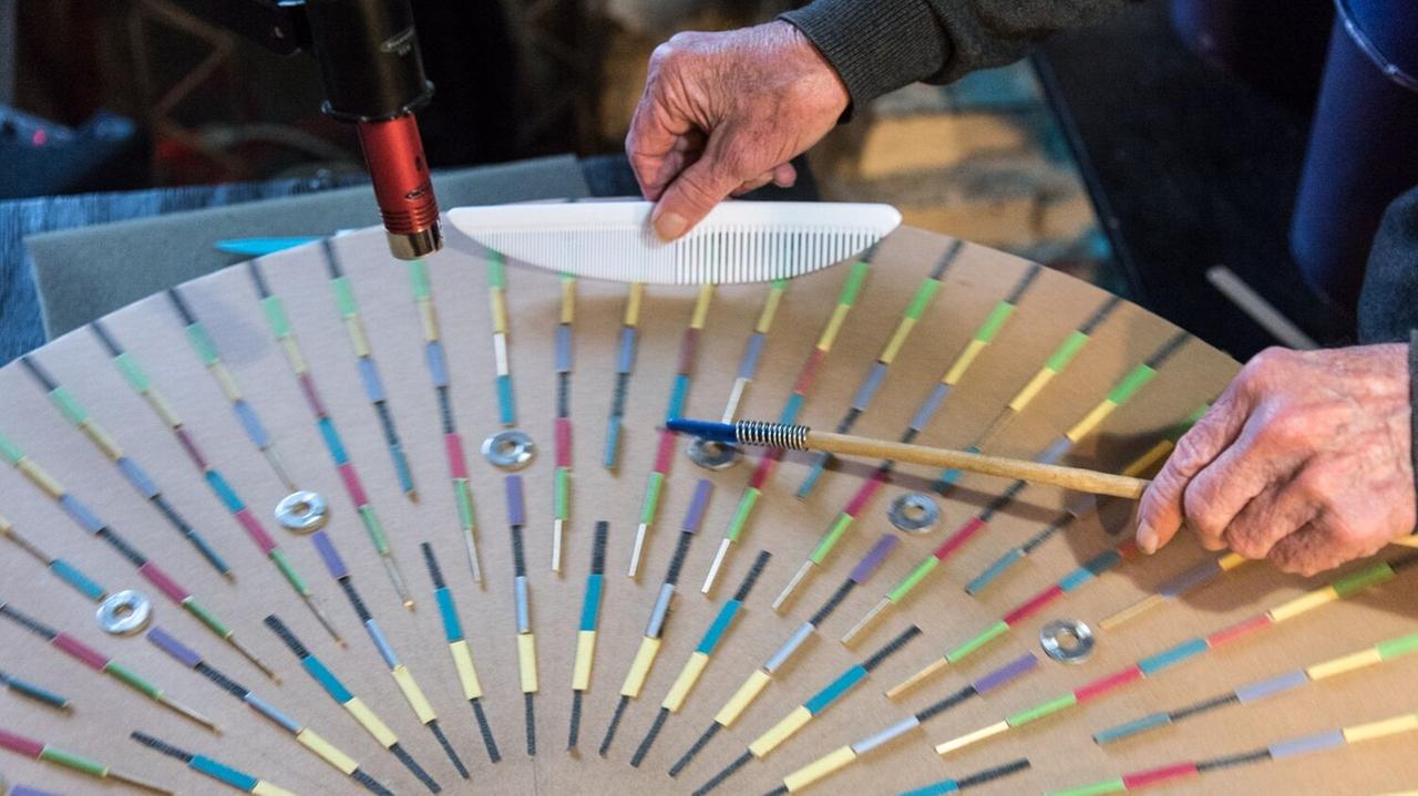 Tom Nunn spielt sein "Giant Skatchwheel (#2)" mit speziell geformten Kämmen, die den Objekten stimmartige Klänge entlocken. Tom Nunn spielt sein "Giant Skatchwheel (#2)" mit speziell geformten Kämmen, die den Objekten stimmartige Klänge entlocken.