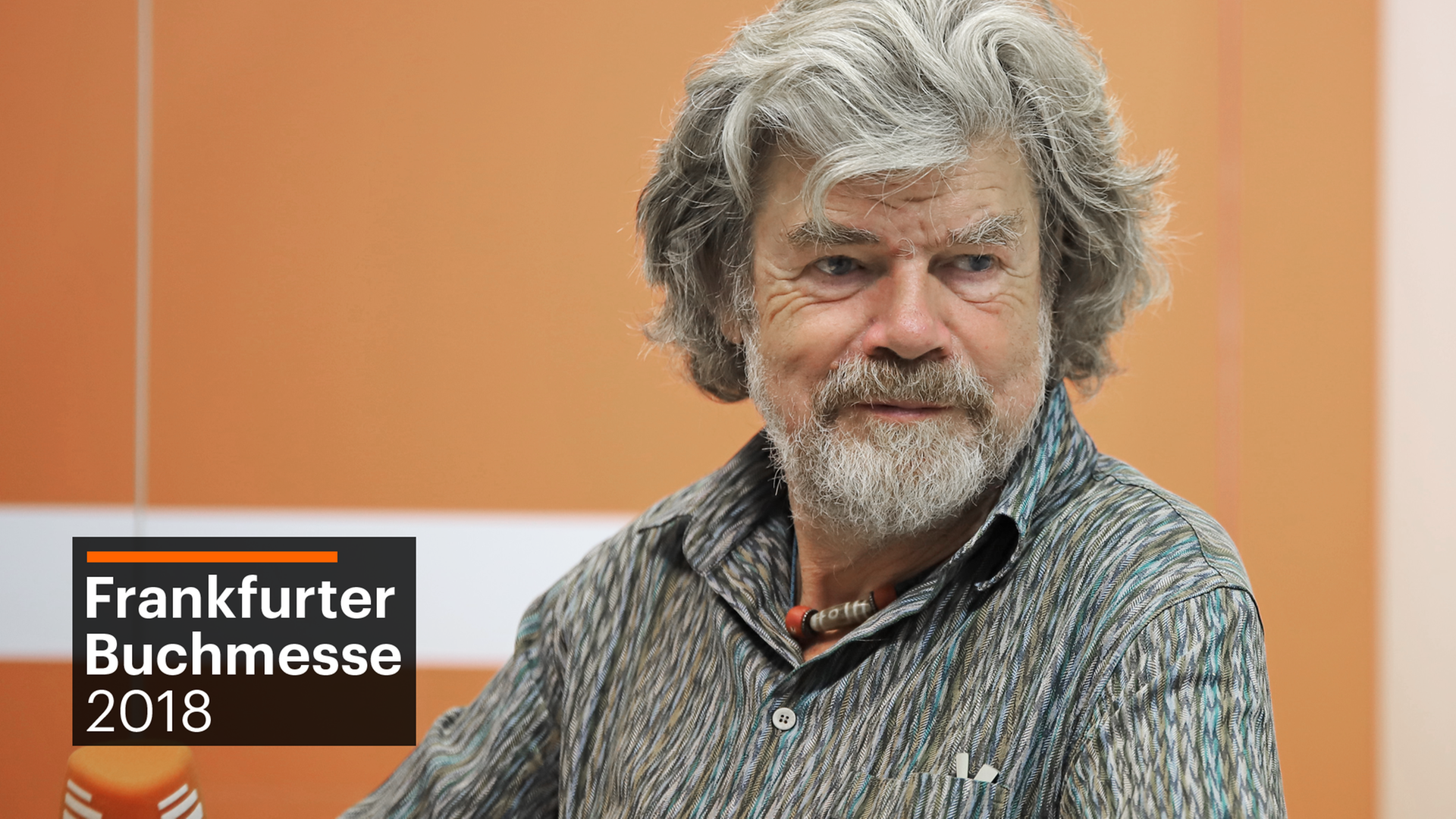 Reinhold Messner sitzt mit einem Mikro in der Hand auf einem Stuhl und spricht mit der Moderatorin der Sendung. Reinhold Messner sitzt mit einem Mikro in der Hand auf einem Stuhl und spricht mit der Moderatorin der Sendung.