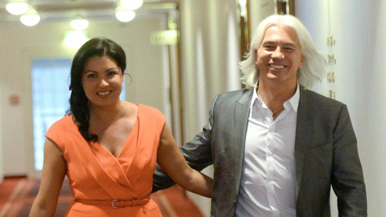 Ein Mann und eine Frau gehen Arm in Arm über einen hell erleuchteten edlen Flur und lachen der Kamera entgegen. Ein Mann und eine Frau gehen Arm in Arm über einen hell erleuchteten edlen Flur und lachen der Kamera entgegen.