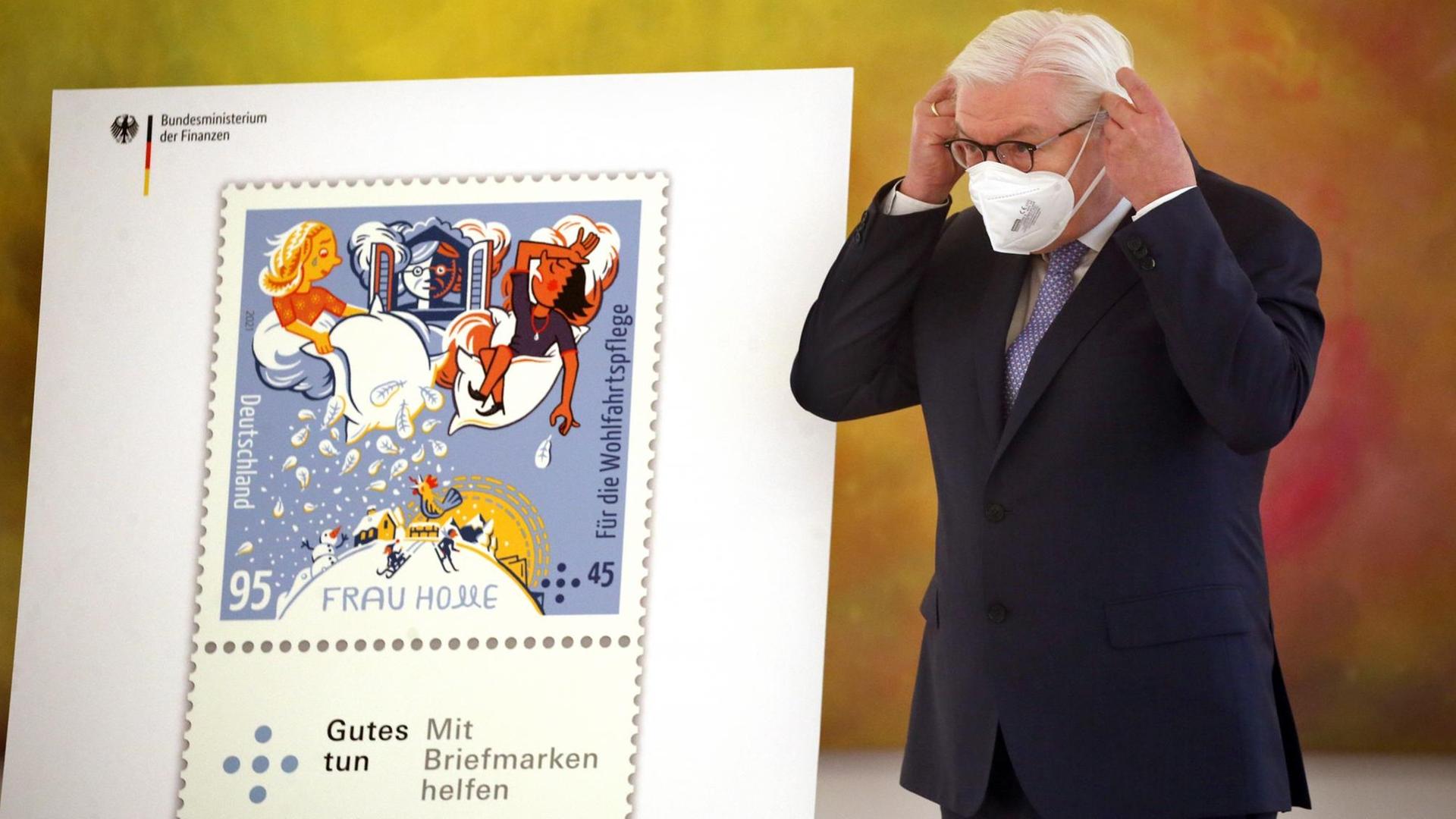 Bundespräsident Frank-Walter Steinmeier nimmt im Schloss Bellevue seine Mund-Nasenschutzmaske ab, bevor der Bundesfinanzminister ihm die Wohlfahrtsmarken 2021 übergibt. Bundespräsident Frank-Walter Steinmeier nimmt im Schloss Bellevue seine Mund-Nasenschutzmaske ab, bevor der Bundesfinanzminister ihm die Wohlfahrtsmarken 2021 übergibt.