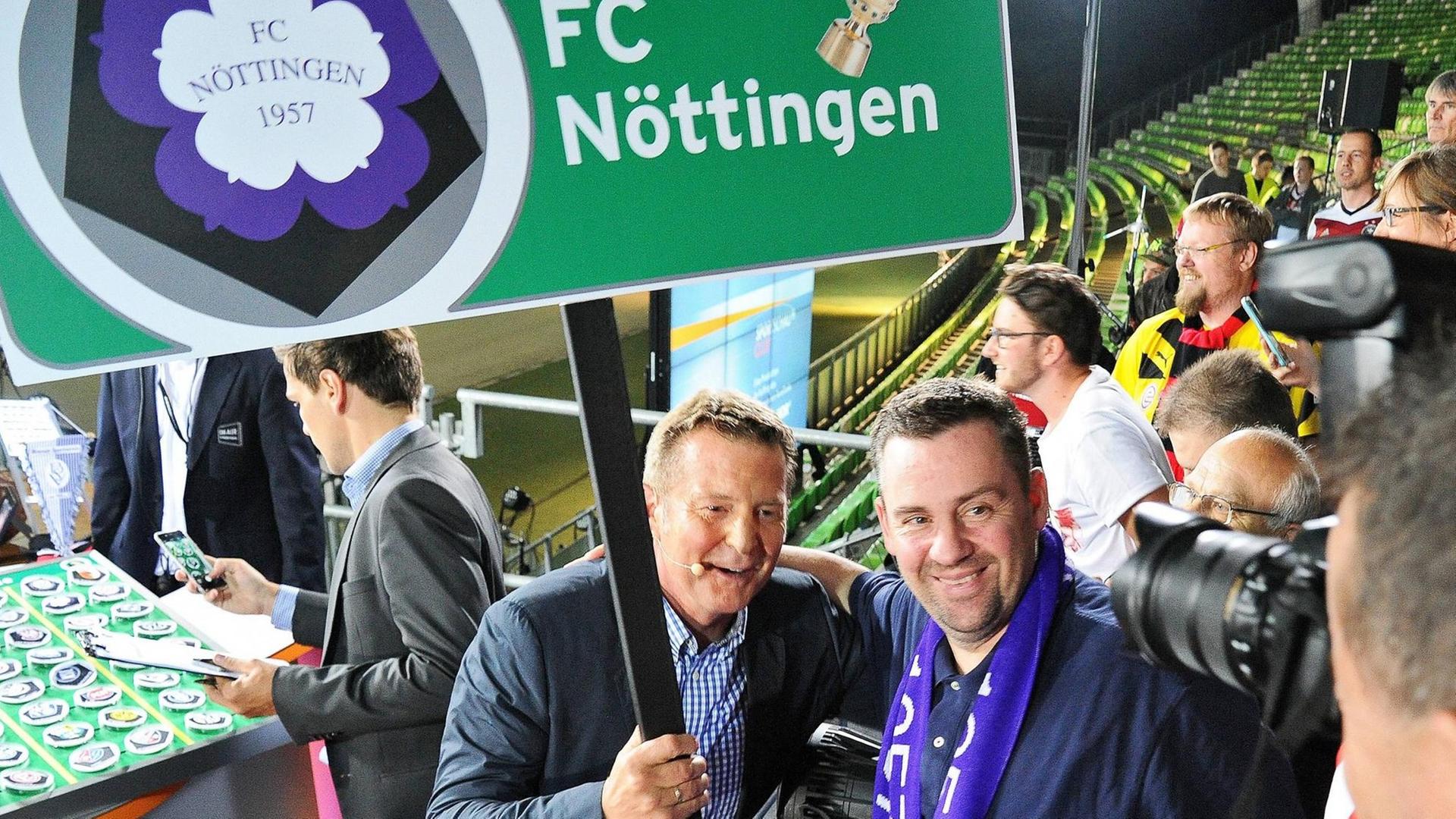 Dirk Steidl (links) vom FC Nöttingen bei der Auslosung zum DFB-Pokal 2015. Seinem Verein wurde der FC Bayern zugelost. Dirk Steidl (links) vom FC Nöttingen bei der Auslosung zum DFB-Pokal 2015. Seinem Verein wurde der FC Bayern zugelost.