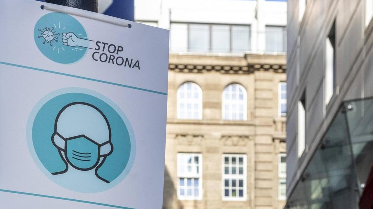 "Stop Corona" steht auf einem Hinweisschild in einer Fußgängerzone in der Innenstadt von Dortmund