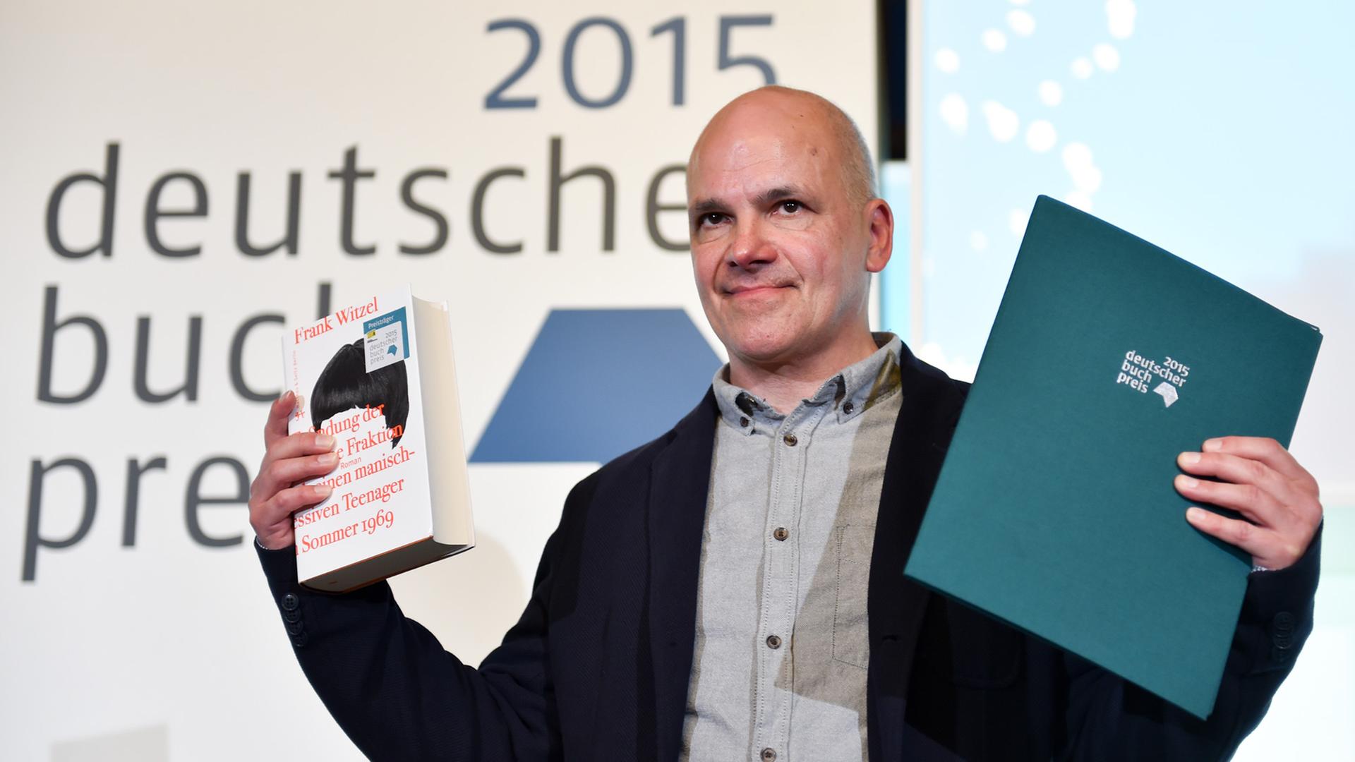 Frank Witzel steht im Römer in Frankfurt am Main mit dem Deutschen Buchpreis 2015 und einem Exemplar seines Buches «Die Erfindung der Roten Armee Fraktion durch einen manisch-depressiven Teenager im Sommer 1969» auf der Bühne. Frank Witzel steht im Römer in Frankfurt am Main mit dem Deutschen Buchpreis 2015 und einem Exemplar seines Buches «Die Erfindung der Roten Armee Fraktion durch einen manisch-depressiven Teenager im Sommer 1969» auf der Bühne.