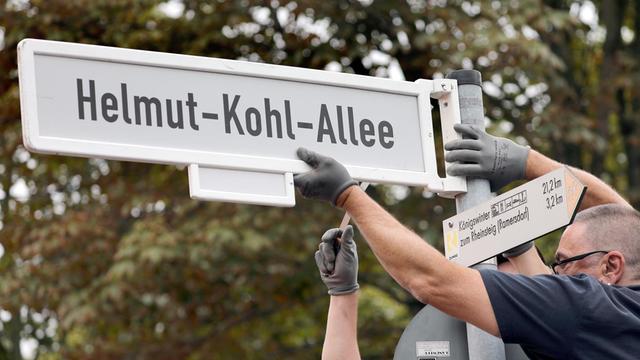Nordrhein-Westfalen, Bonn: Mitarbeiter der Stadt Bonn befestigen das Straßenschild der Helmut-Kohl-Allee.