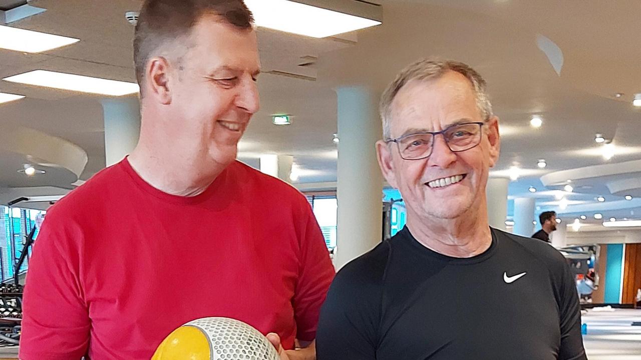 Zwei Männer stehen in einem Sportstudio. Beide halten einen Ball in der Hand. Zwei Männer stehen in einem Sportstudio. Beide halten einen Ball in der Hand.