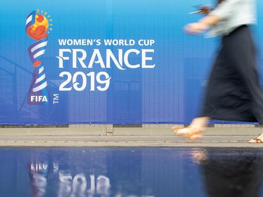 Eine Frau geht an einem Banner für die Fußball-Weltmeisterschaft der Frauen in Frankreich 2019 am Stadion Roazhon Park vorbei.