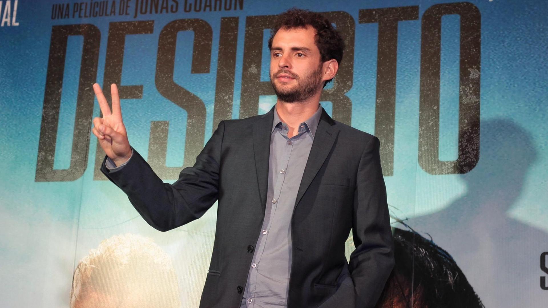 Regisseur Jonas Cuaron posiert mit dem Victory-Zeichen vor einem 'Desierto' Plakat in Mexico City