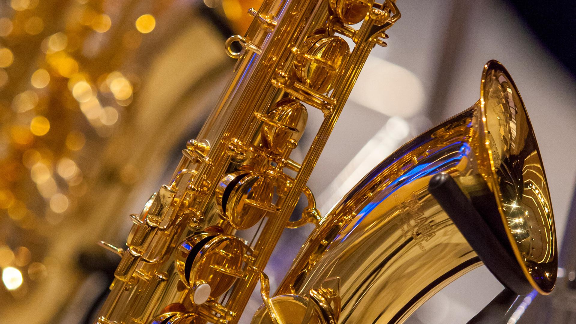 Ein Saxophon steht vor einem Orchesterkonzert auf der Bühne. Ein Saxophon steht vor einem Orchesterkonzert auf der Bühne.