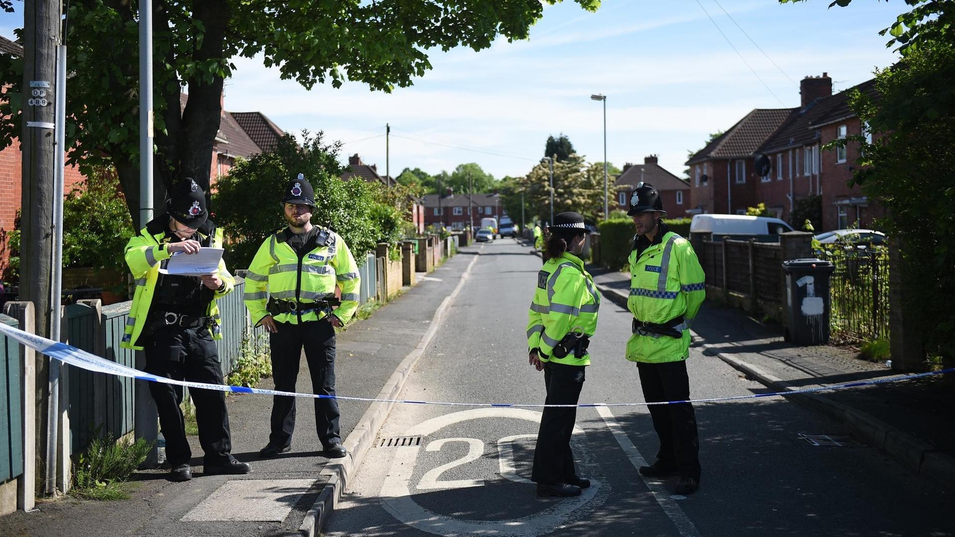 Polizisten im Stadtteil Fallowfield in Manchester an einer abgesperrten Straße, an der ein Haus durchsucht wurde. Polizisten im Stadtteil Fallowfield in Manchester an einer abgesperrten Straße, an der ein Haus durchsucht wurde.