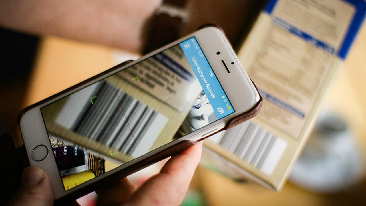 Mit einem Smartphone, auf dem eine Labelapp installiert ist wird der Barcode eines Produktes eingescannt. Mit einem Smartphone, auf dem eine Labelapp installiert ist wird der Barcode eines Produktes eingescannt.