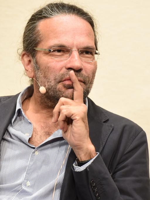 Der Philosoph Robert Pfaller spricht an einem Redepult.