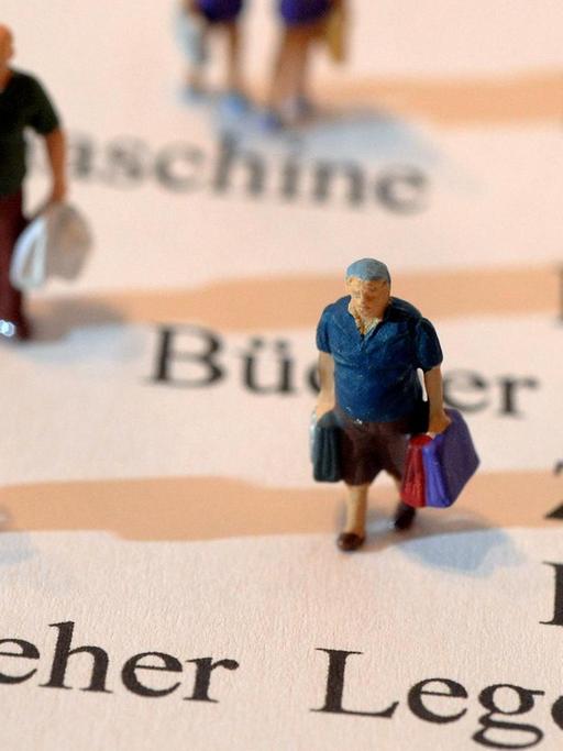 Miniatur-Figuren, die Einkaufstüten in Händen halten